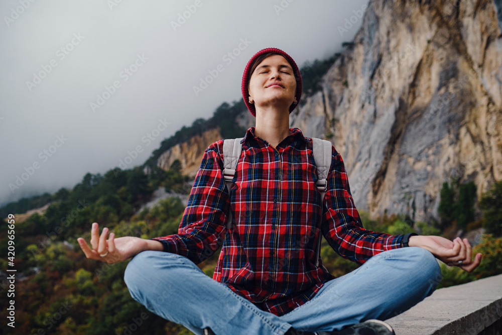 Asian hipster woman walking alone on a mountain highway on an autumn foggy day Asian hipster woman walking alone on a mountain highway on an autumn foggy day