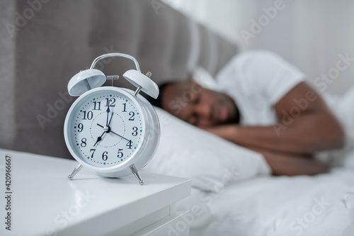 A young man in white sleeping and looking peaceful