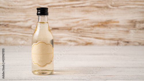A small bottle of coffee syrup on wooden table. Coffee syrup in mini bottle