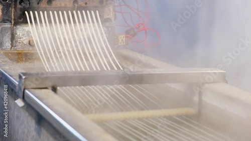 Recycled molten plastic comes out of the extruder machine Concept of recycling, plastic, industry, factories. Continuous extrusion with cooling in water to be processed into a pellet.