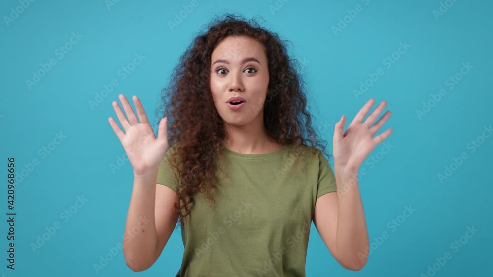 Confused african american woman 20s in casual green khaki t-shirt posing isolated on blue background in studio. People lifestyle concept. Point finger herself ask say who me no thanks i do not need it Confused african american woman 20s in casual green khaki t-shirt posing isolated on blue background in studio. People lifestyle concept. Point finger herself ask say who me no thanks i do not need it