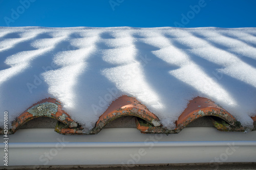 Snow covered mediterranean roof tiles photo