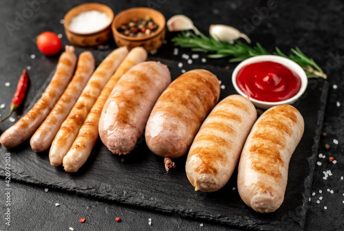 different grilled sausages on a stone background