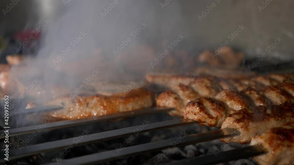 Cooking meat and delicious food concept. Meat on skewers. Marinated shashlik preparing on a barbecue grill over charcoal. Cooking meat and delicious food concept. Meat on skewers. Marinated shashlik preparing on a barbecue grill over charcoal.