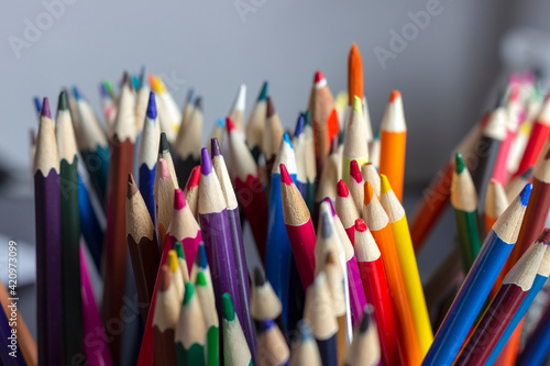 A large set of colored pencils, standing on the table in a stand.