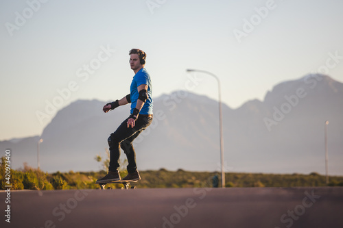 Skateboarder skateboarding on an open road doing freestyle tricks