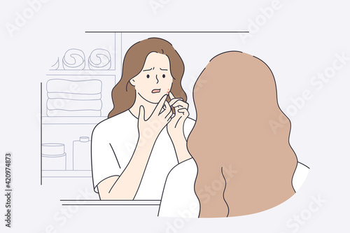 Skincare, skin problems, pimples concept. Beautiful girl in white t-shirt cartoon character squeezing pimples on her face while looking into mirror in bathroom feeling unhappy vector illustration 