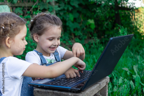 Young hackers working on a laptop in the summer in the garden