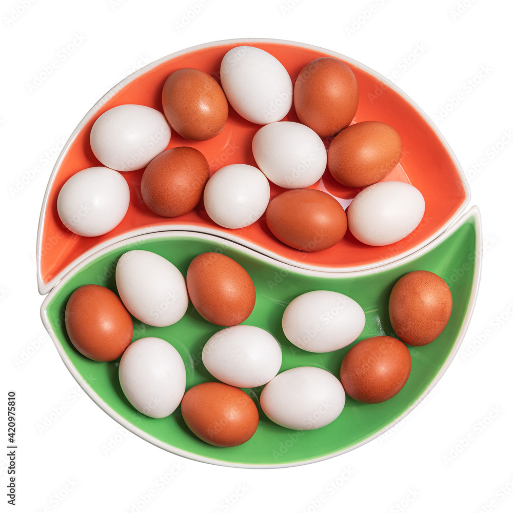 White and brown chicken eggs on a round platter. Flat lay. Isolated