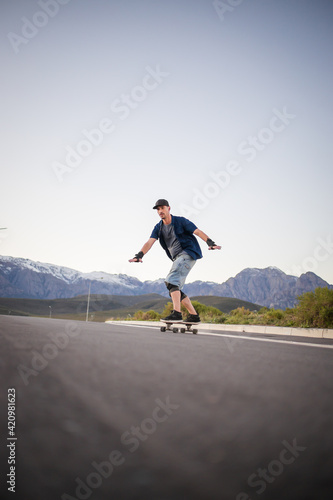 Close up image of a skateboarder skating his skateboard down the road.