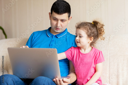 Caring father and daughter doing homework online. child preschooler studying online, using laptop. Man explaining to girl knowledge in computer. Distance Education e-learning homeschooling concept