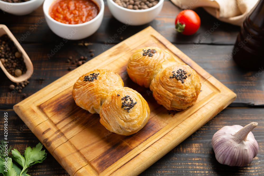 cutting board with delicious baked samosas on wooden background cutting board with delicious baked samosas on wooden background