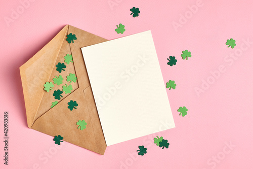 Saint Patricks day greeting card mockup with green paper shamrock on pink background