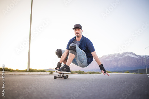 Skateboarder skateboarding on an open road doing freestyle tricks