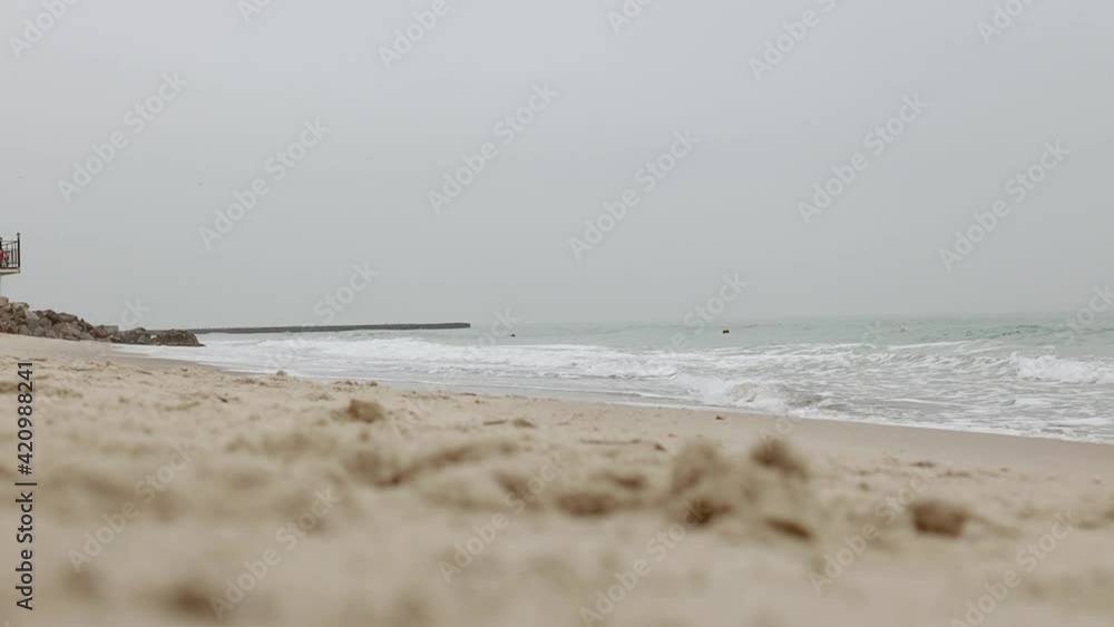 Winter beach with splash wave water. The sea wave crashes against the stone beach. Sea with stormy waves rolling on cloudy cold winter day. Winter beach with splash wave water. The sea wave crashes against the stone beach. Sea with stormy waves rolling on cloudy cold winter day.