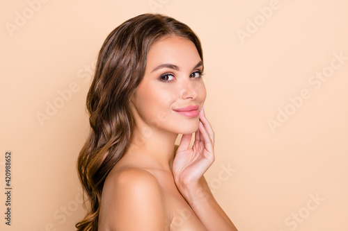 Photo of young beautiful lovely smiling woman naked shoulders apply skin product isolated on beige color background