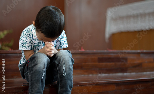 Young Christian Asian Boy Sitting on Steps Praying to God at Church with Hope and Faith