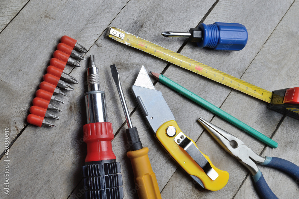 some home repair tools lie on a wooden background. close-up. some home repair tools lie on a wooden background. close-up.