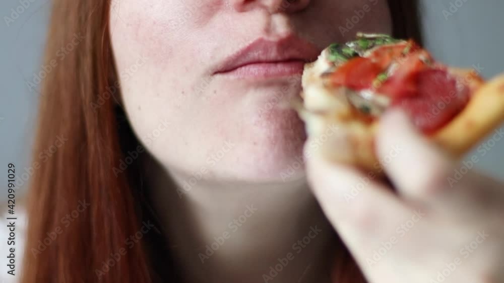 Funny woman eating a piece of taste Italian pizza. Hungry woman, close-up Funny woman eating a piece of taste Italian pizza. Hungry woman, close-up