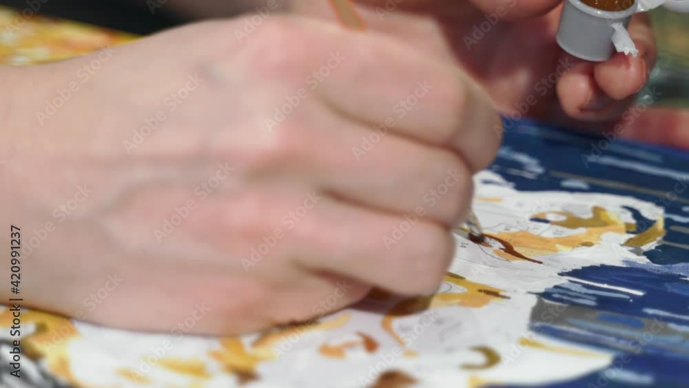 Authentic young woman paints a picture. She is wearing a white shirt. She is in the living room-studio. Shows her inner life. Close up hands and picture by numbers Authentic young woman paints a picture. She is wearing a white shirt. She is in the living room-studio. Shows her inner life. Close up hands and picture by numbers