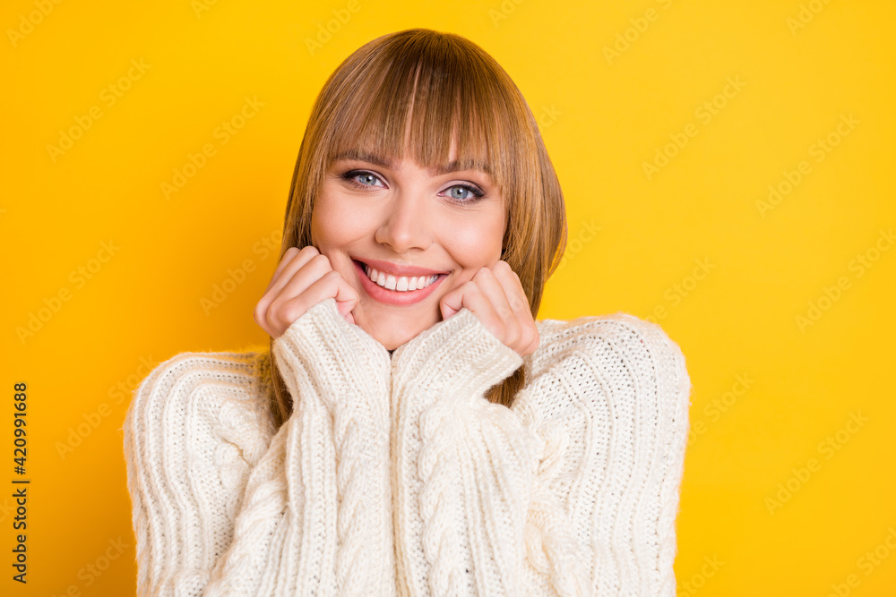Portrait of attractive cheerful lady hands on chin toothy smile wear warm pullover isolated on yellow color background