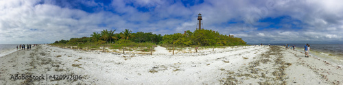 SANIBEL, FL - FEBRUARY 2016: Tourists look for shells on the famous island beach - Panoramic view