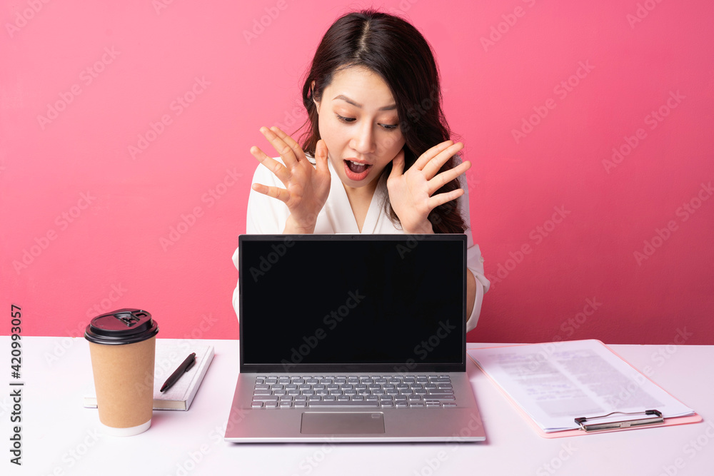 Young Asian businesswoman sitting working with expression on background Young Asian businesswoman sitting working with expression on background
