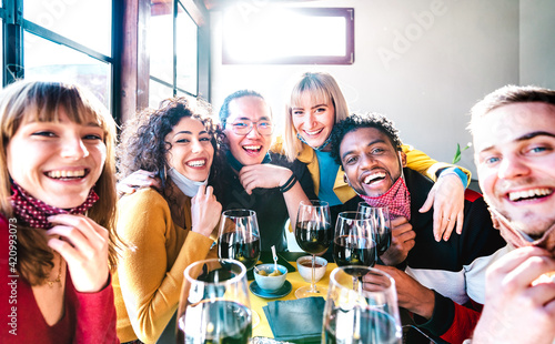 Friends taking selfie at winery bar drinking wine glass with open face mask - People having fun together at restaurant reopening - Selective focus on middle guys and girls with bright backlight filter