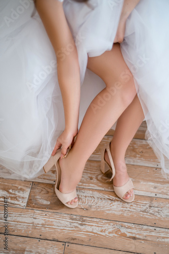 Bride putting on her shoes in the morning. © Nina_Arnis
