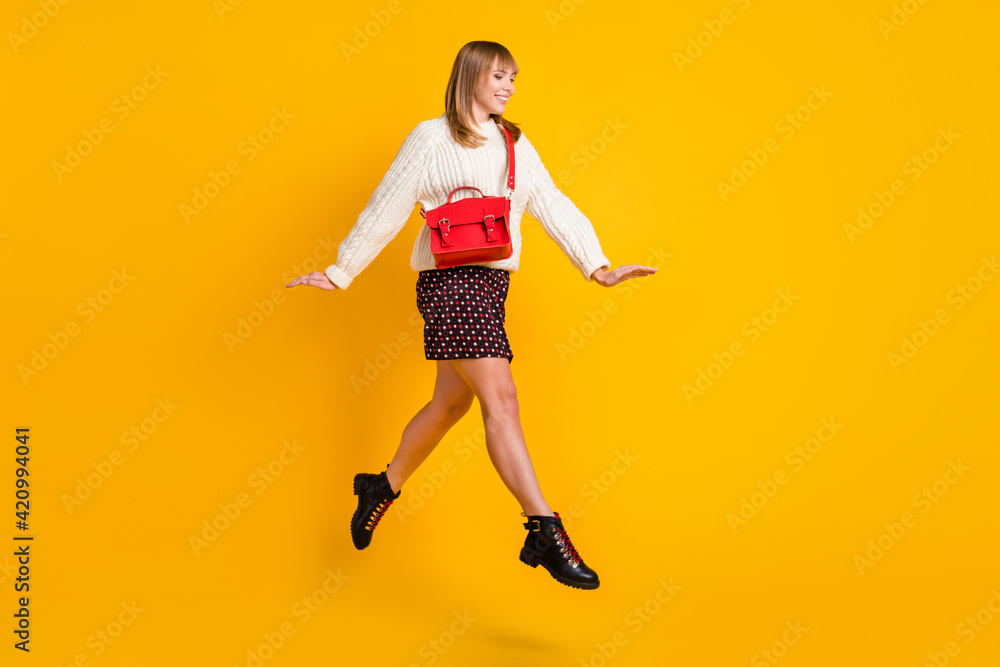 Full body profile photo of cheerful pretty lady jump high running isolated on yellow color background Full body profile photo of cheerful pretty lady jump high running isolated on yellow color background