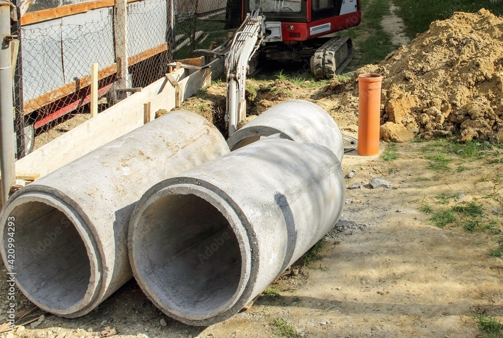Concrete sewer pipes ready for installation in the excavated channel