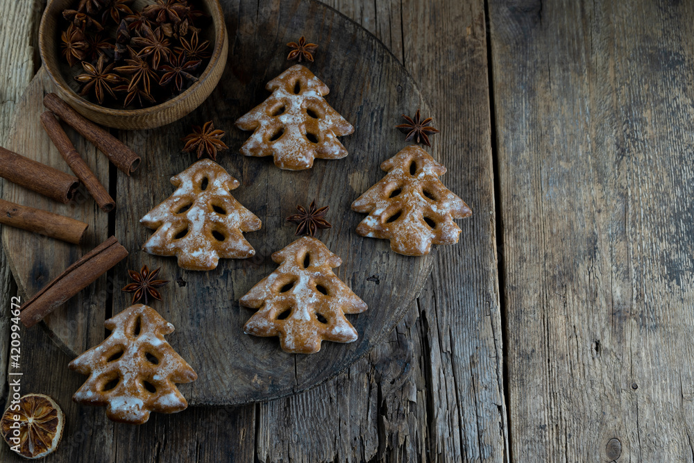 Christmas tree cookies on wooden background. New Year's food. Anise star. Festive baked goods. Gingerbread on the table.Icing sugar sweetness taste season Christmas tree cookies on wooden background. New Year's food. Anise star. Festive baked goods. Gingerbread on the table.Icing sugar sweetness taste season
