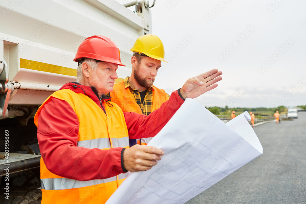 Architekt und Arbeiter mit Lageplan für die Bebauung Architekt und Arbeiter mit Lageplan für die Bebauung