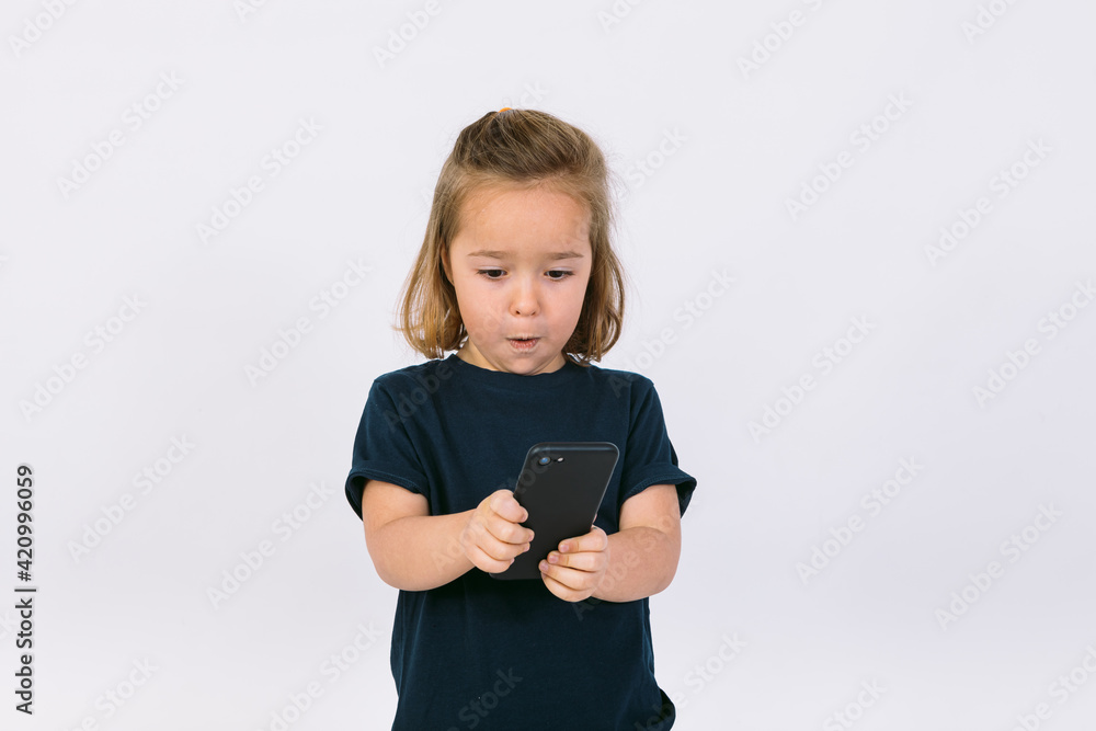 Little blonde girl with mobile phone in her hands, gesturing Little blonde girl with mobile phone in her hands, gesturing