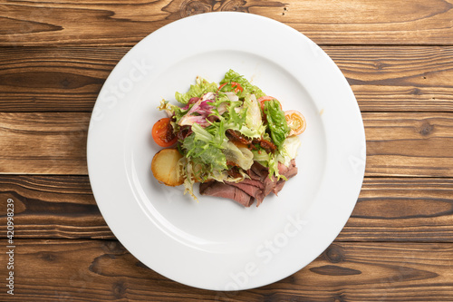 Warm salad with roast beef, baked potatoes and sun-dried tomatoes