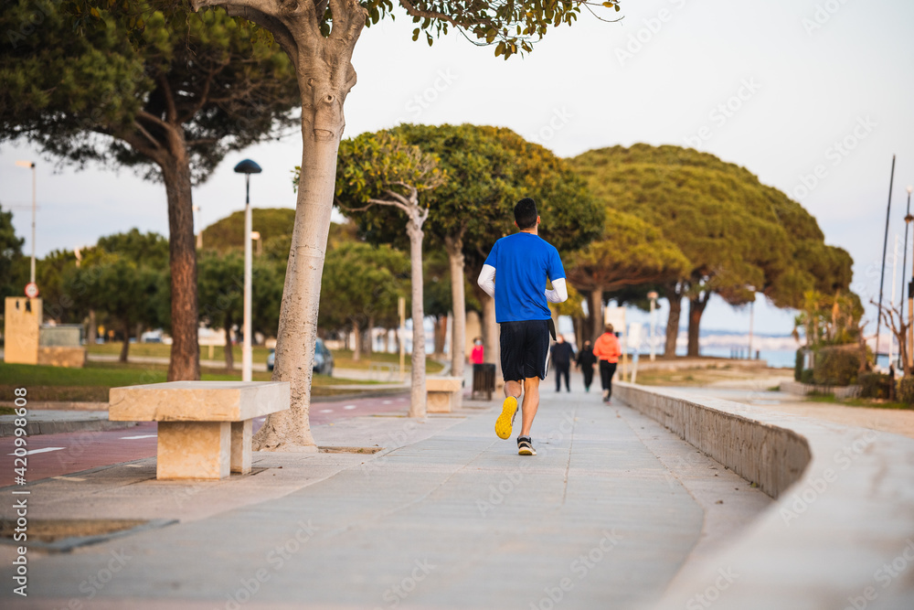 Fototapeta premium Man doing sports on a sea promenade.