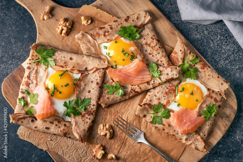 Leinwand Poster Crepes with eggs, salmon, spinach and nuts