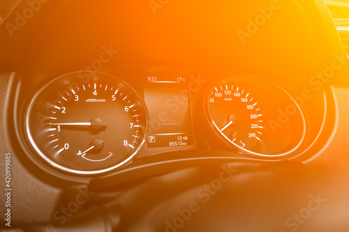 speedometer of a modern car with an integrated fuel gauge in the tank with white arrows under the yellow and orange neon color.. photo