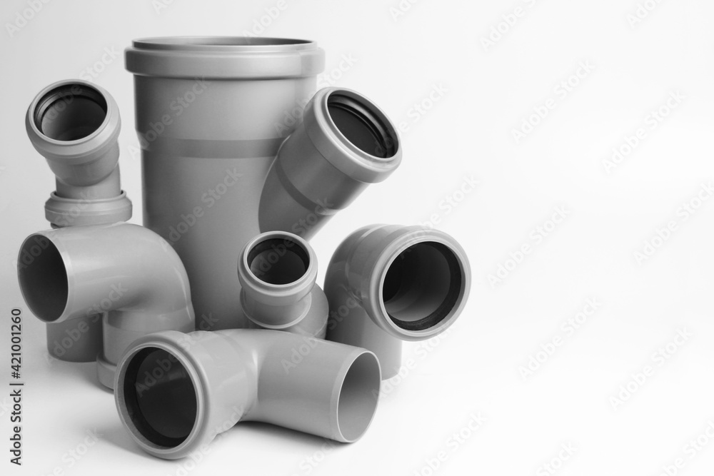 PVC plastic water pipes in gray color, insulated on a white background. The concept of installation, replacement of plastic pipes, plumbing. Copyspace. PVC plastic water pipes in gray color, insulated on a white background. The concept of installation, replacement of plastic pipes, plumbing. Copyspace.