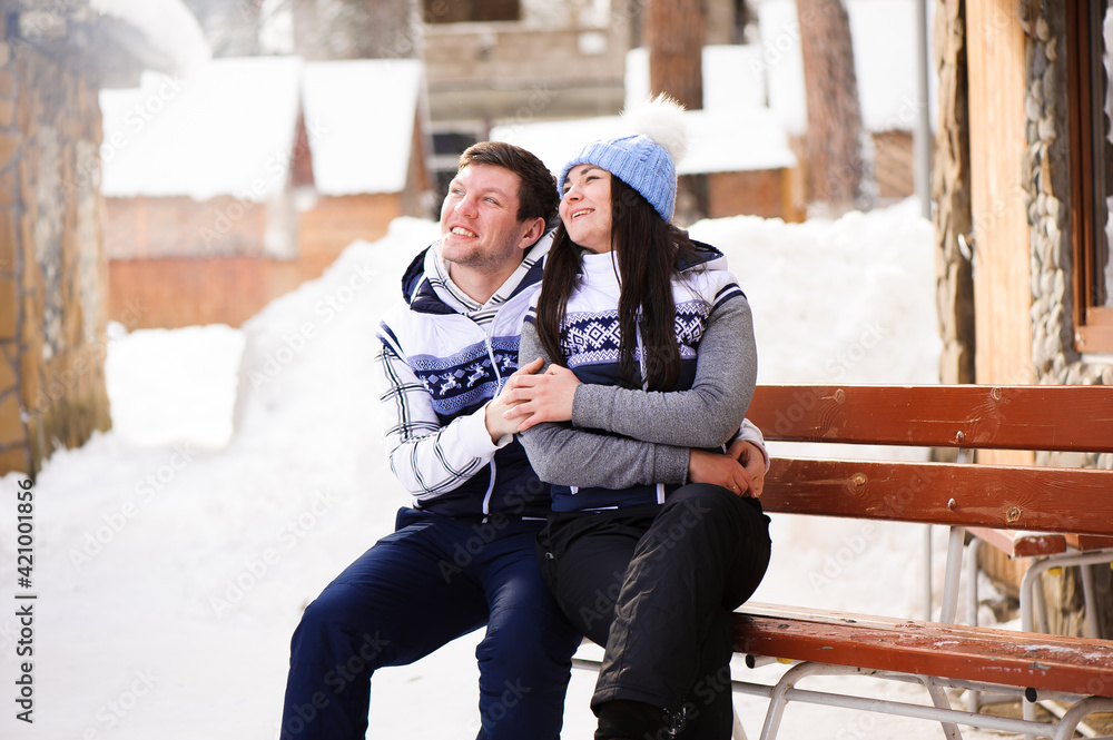 Happy couple in love hugging and kissing at winter resort Happy couple in love hugging and kissing at winter resort