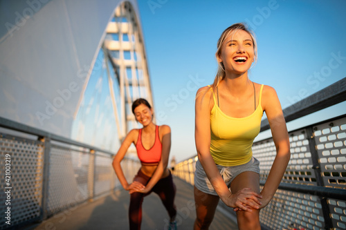 Fototapeta Naklejka Na Ścianę i Meble -  Beautiful happy women friends working out, exercising, running, jogging outdoor.