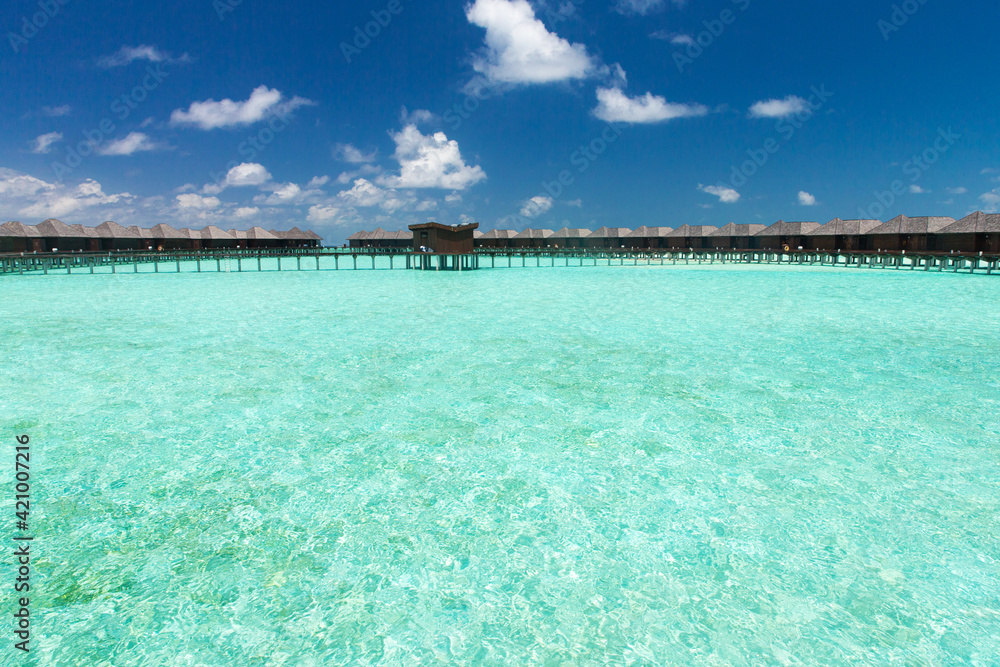 Beautiful tropical Maldives island with beach. Sea with water bungalows