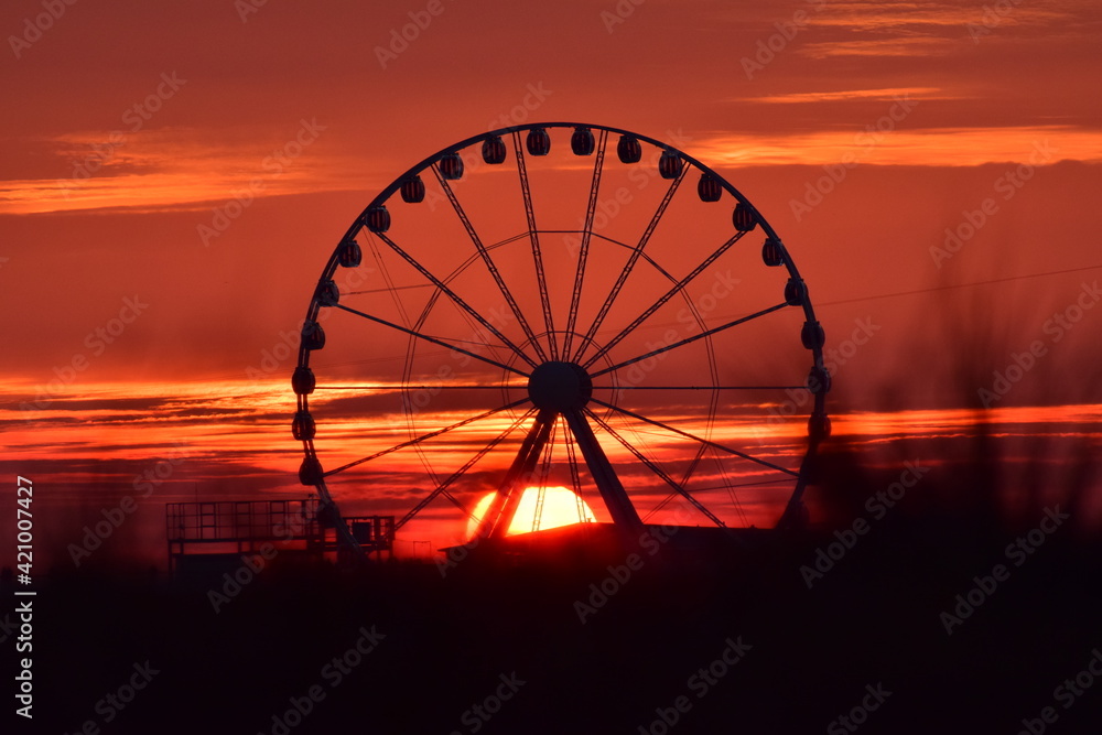 sunset  through Ferris wheels