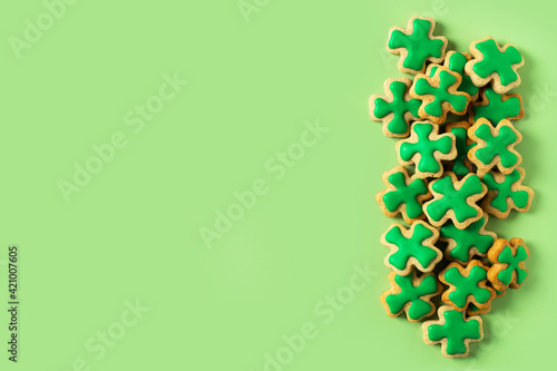Saint Patrick s day concept with green cookies shamrock on green background 