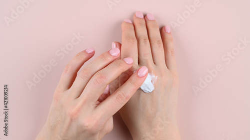 Girl smears hand cream, top view