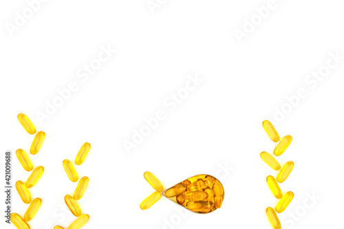 Omega-3 fish oil capsules in a shape of a fish on white background