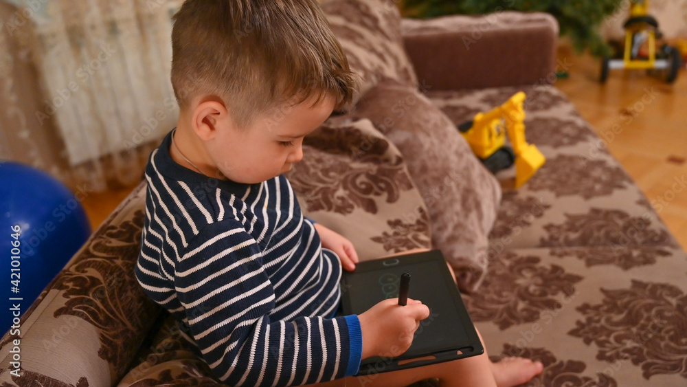 Child draws on a graphics tablet Child draws on a graphics tablet