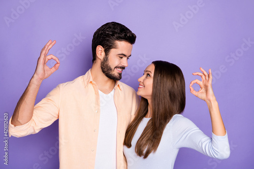 Photo of trendy romantic brunette couple show ok sign look each other harmony isolated on purple color background