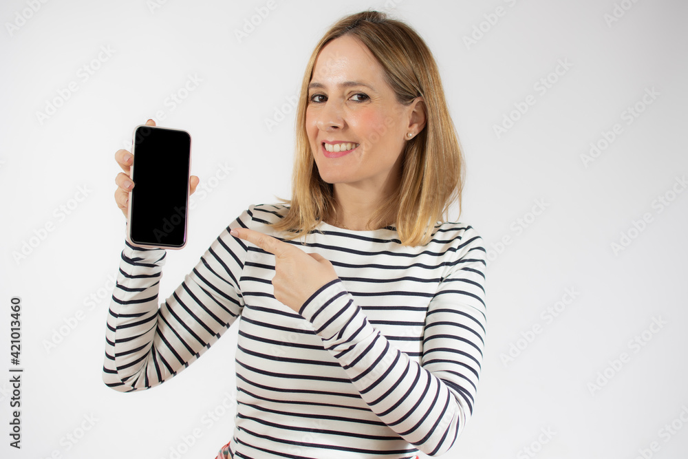 Portrait of a smiling young woman showing blank screen mobile phone while standing isolated over white background Portrait of a smiling young woman showing blank screen mobile phone while standing isolated over white background