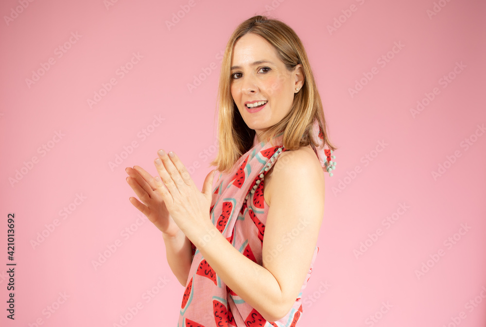 Young woman feeling happy and successful, smiling and clapping hands isolated over pink background. Young woman feeling happy and successful, smiling and clapping hands isolated over pink background.